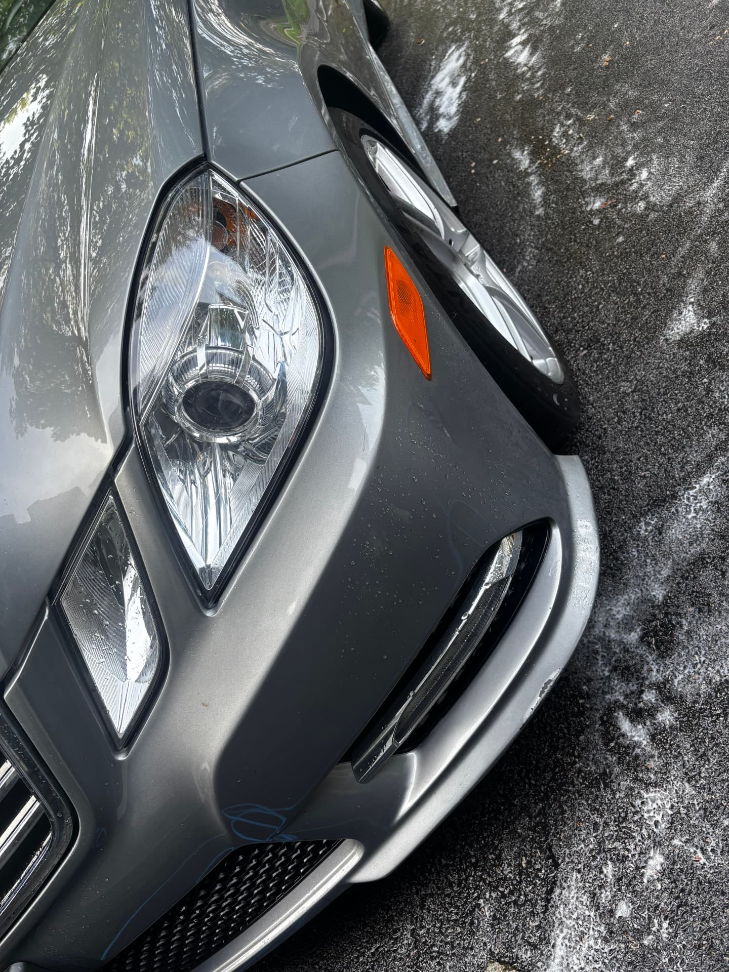 Clean headlight and paint on a gray Mercedes after a hand wash