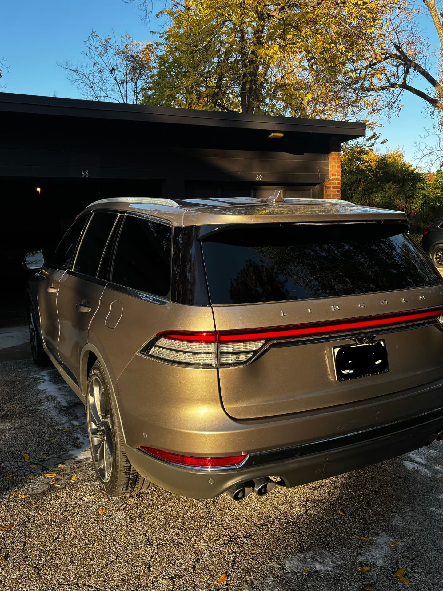 Rear of a bronze Lincoln SUV in a driveway after a hand wash by Lucent Car Care