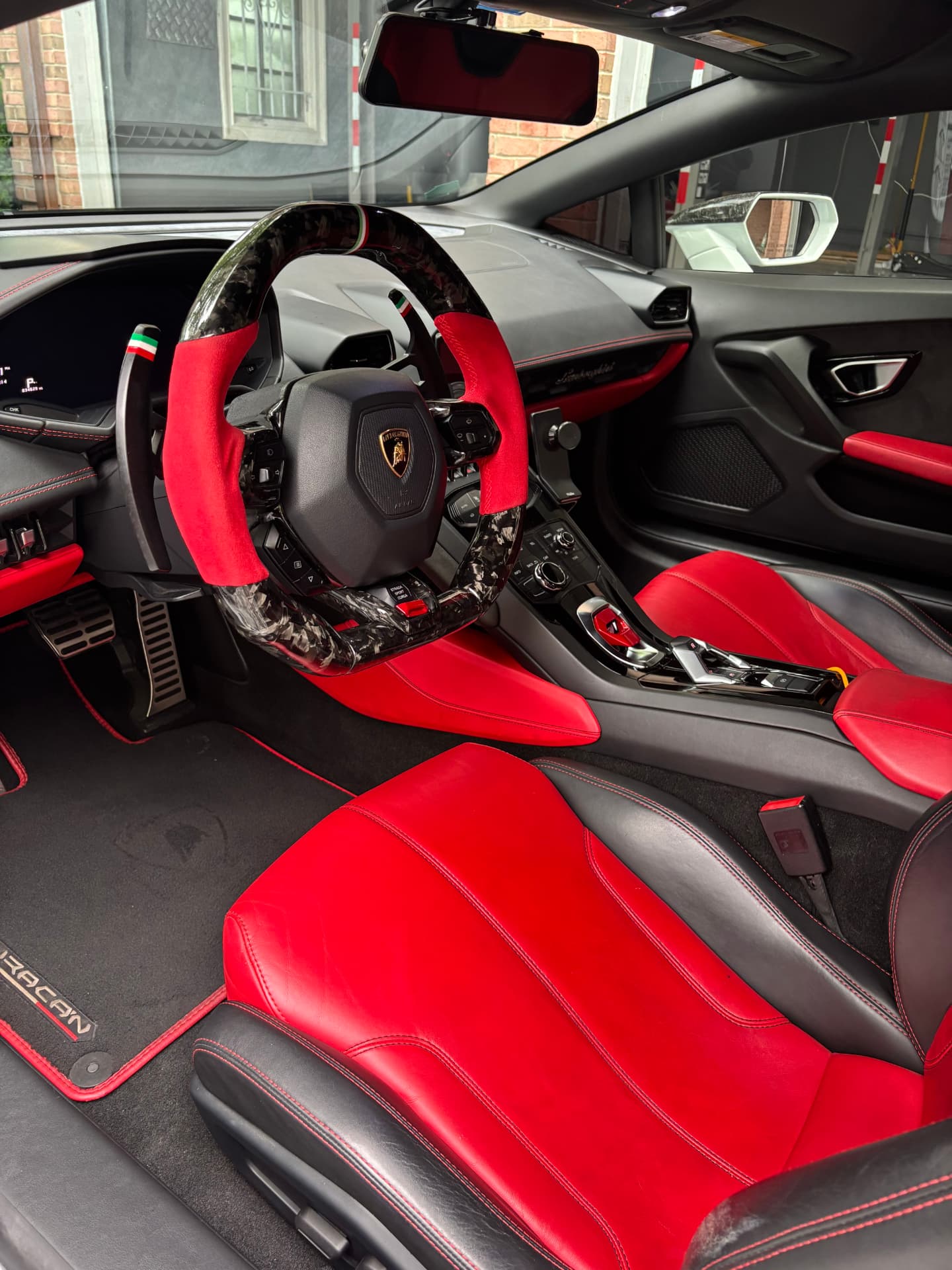 Red leather seats and steering wheel of a Lamborghini after an interior detail