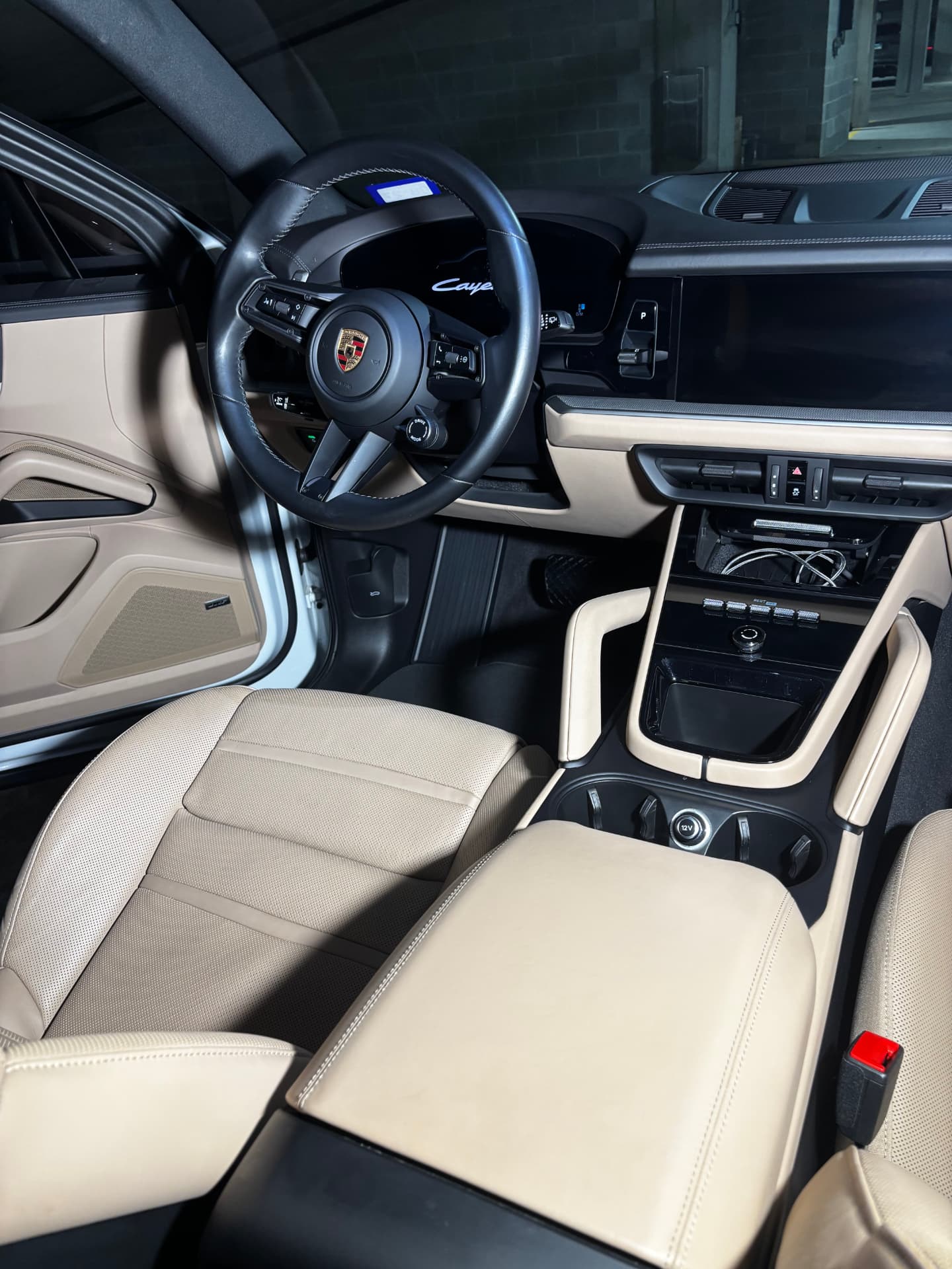Cream leather seats and center console inside a Porsche Cayenne after an interior detail