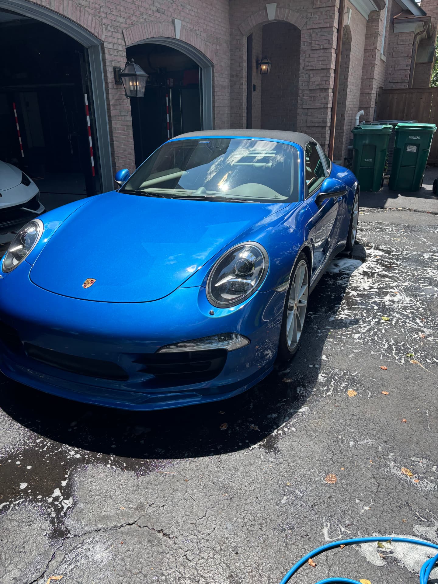 Blue Porsche 911 with glossy paint after a hand wash in a North Shore driveway