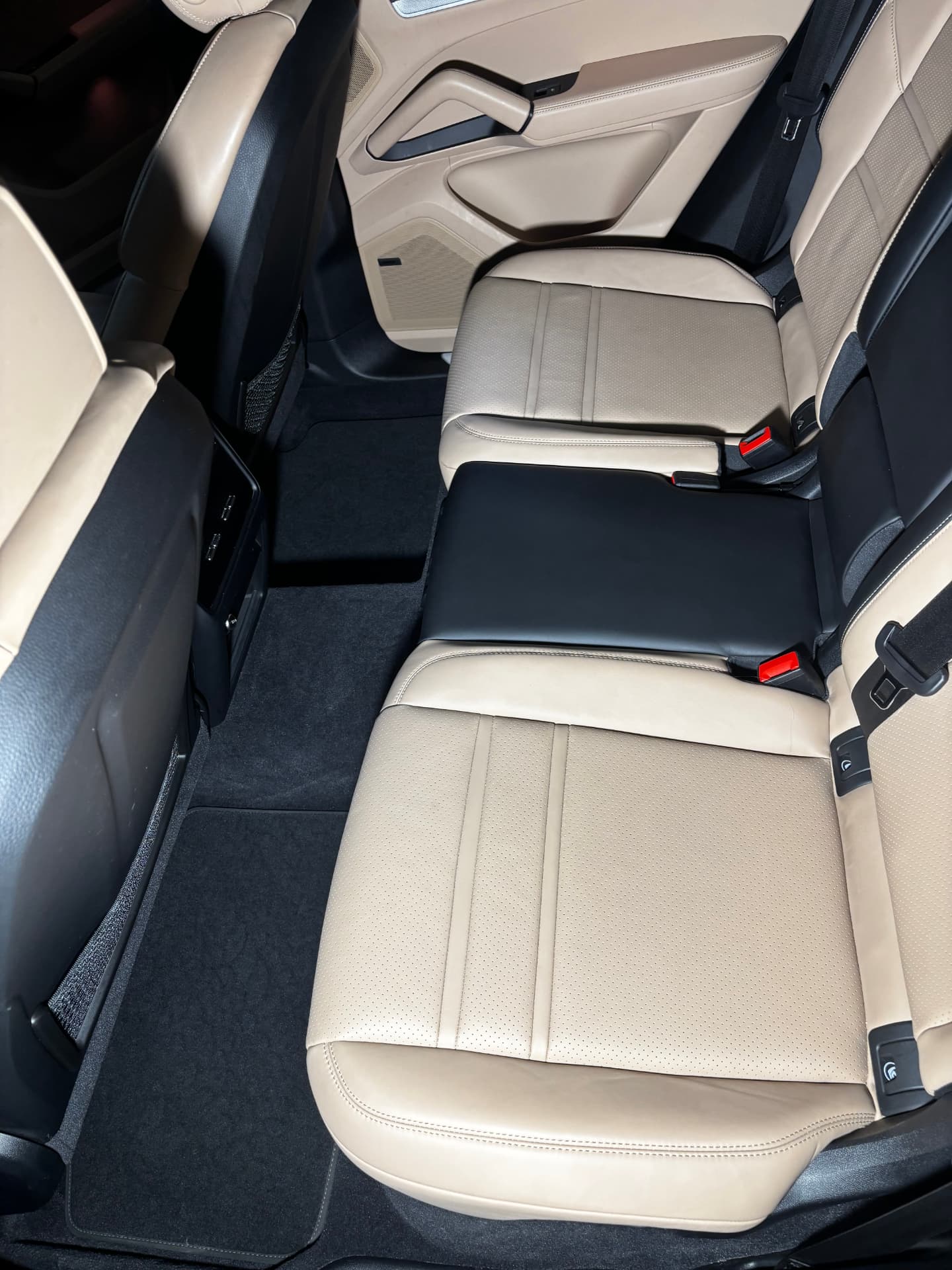 Cream leather rear seats and clean carpet inside a Porsche Cayenne after an interior detail